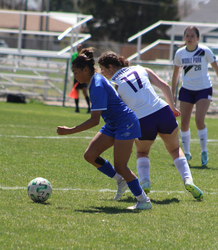Fort Lupton's Rylee Balcazar (blue) chases down the loose ball during a match against Middle Park last month.